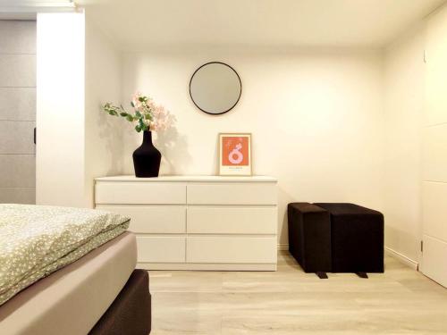 a bedroom with a bed and a dresser with a mirror at Flair-Apartments 'SALZ & FLAIR' Kurstadt-Appartment, 450 m Bahnhof, für Urlaub oder Geschäftsreise, innenstadtnah, separater Eingang, 24 Std Check-in,WLAN, 55 Zoll-Fernseher, Streaming, Küche, Regendusche, Doppelbett, Schlafsofa in Bad Salzuflen