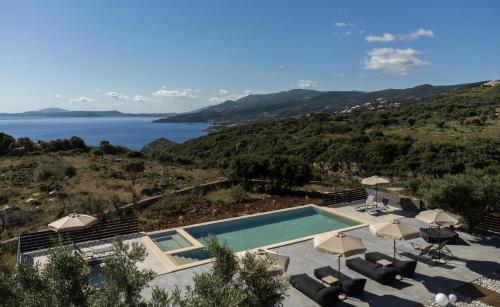 a villa with a swimming pool and a view of the water at Marea Luxury Suites in Koríthion