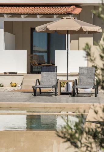 two chairs and an umbrella next to a pool at Marea Luxury Suites in Koríthion