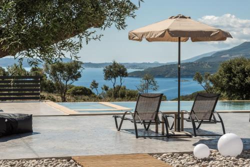 two chairs and an umbrella next to a swimming pool at Marea Luxury Suites in Koríthion