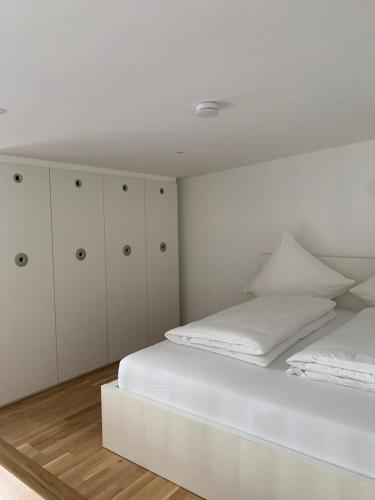 a white bedroom with two beds and white cabinets at Appartement am Bahnhof in Straubing