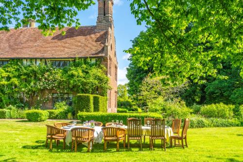 a table and chairs in front of a house at Spectacular thousand year old Medieval manor house - Flemings Hall in Ipswich