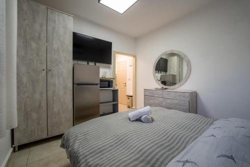 a bedroom with a bed and a refrigerator and a mirror at אדום 179, דירות נופש in Eilat