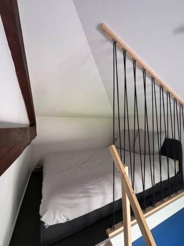 un petit lit dans une chambre avec une rampe d'escalier dans l'établissement Le 19 Saint Priest en Jarez T1, à Saint-Priest-en-Jarez