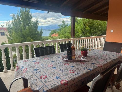 a table on a balcony with a view of the water at Apartmani Greif in Gornji Karin