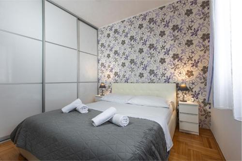 a bedroom with a bed with two pillows on it at Poolhouse Domus in Solin