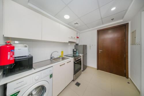 a kitchen with a washing machine and a sink at RAKvista Beach Residence- Marjan Island in Ras al Khaimah
