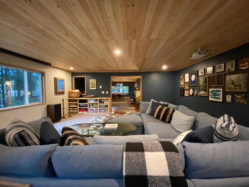 a living room with a blue couch and wooden ceiling at Elk Lodge in Packwood