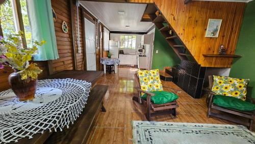 a living room with a staircase and green walls at Residencial Recanto Paraíso BC - Chalé da Árvore in Balneário Camboriú