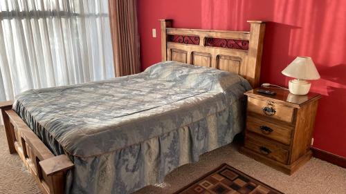 a bedroom with a bed and a table with a lamp at Muy cerca, a pasos de la Embajada de EEUU in La Paz
