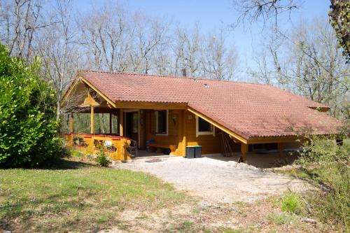 une petite maison jaune avec un toit rouge dans l'établissement Chalet village vacances, à Mauroux
