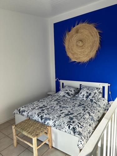 une chambre avec un lit avec un mur bleu dans l'établissement L'EFFET MER, DUPLEX SUR LE PORT AVEC SES 2 TERRASSES VUE MER, à Hyères