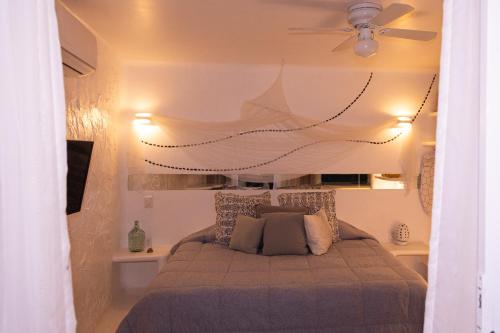 a bedroom with a bed with a ceiling fan at El Sho - Hotel orgánico in Bucerías