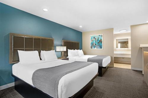 two beds in a room with blue walls and two beds sidx sidx sidx at Best Western Big Country Inn in Coalinga
