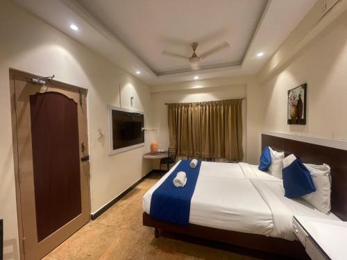 a bedroom with a large bed and a television at AKG Lodge in Kanchipuram