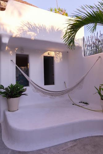 a hammock on the side of a white building at El Sho - Hotel orgánico in Bucerías