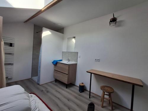 - une chambre avec un bureau, un lit et une table dans l'établissement Gîte au milieu de la campagne, à La Chapelle-Viviers