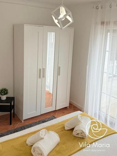 a bedroom with a bed with two pillows on it at Vila Maria Beach Apartments in Pataias