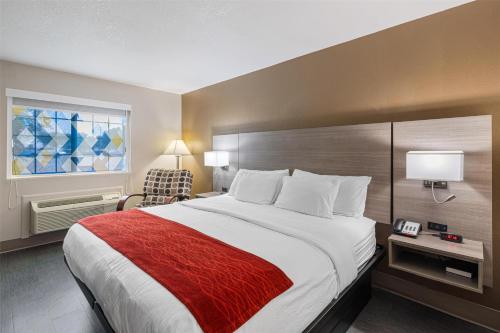 a hotel room with a large bed with a red blanket at SureStay Plus Hotel by Best Western Kearney in Kearney