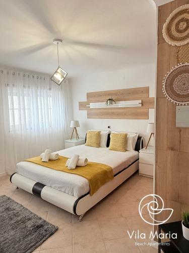 a bedroom with a large bed in a room at Vila Maria Beach Apartments in Pataias