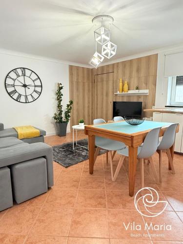 a living room with a table and a couch at Vila Maria Beach Apartments in Pataias
