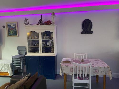 a room with a table and a hutch with purple lighting at Almost Heaven - 4 min drive from Donegal Town in Red Bridges