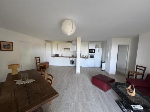 a living room with a dining table and a kitchen at REZ de VILLA Entre Mer et Maquis Appartement indépendant in Coti-Chiavari