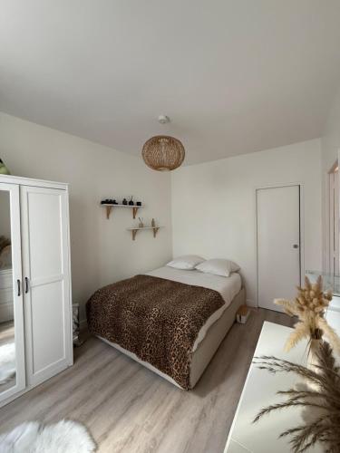 une chambre blanche avec un lit et une table dans l'établissement Appartement T2 cooconing, Paris 11ème, à Paris