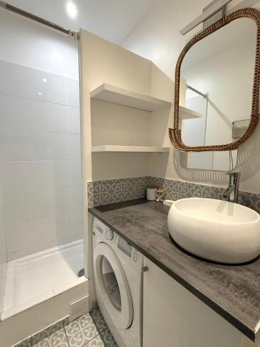 une salle de bain avec une machine à laver et un lavabo dans l'établissement Appartement T2 cooconing, Paris 11ème, à Paris