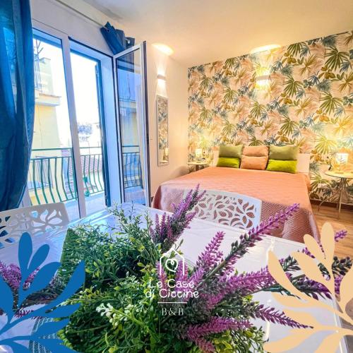 a bedroom with a bed and some purple flowers at Le Case di Ciccine' in Bagheria