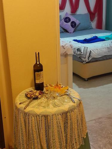 a table with a bottle of wine and glasses on it at Villa İnci in Cesme