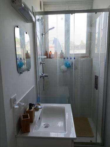 La salle de bains est pourvue d'une douche et d'un lavabo blanc. dans l'établissement Villa Odette beach, à Villers-sur-Mer