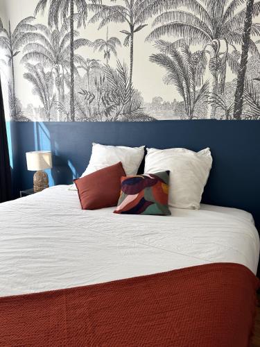 une chambre avec un lit avec un mur bleu avec des palmiers dans l'établissement Appartement 40m2 - Hyper Centre, à Brest