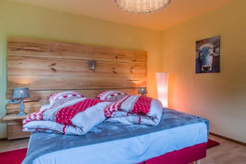 a bedroom with a bed with a wooden headboard and pillows at Alte Schreinerei-Auberge Harlekin in Singen