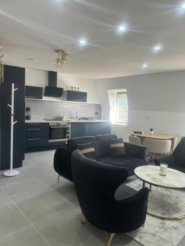 un salon avec des canapés et une table ainsi qu'une cuisine dans l'établissement By cité de la gastronomie, à Dijon