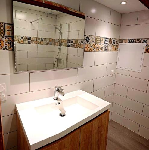 une salle de bain avec un lavabo blanc et un miroir dans l'établissement Appartement 3 chambres vallée du Lot, à Capdenac-Gare