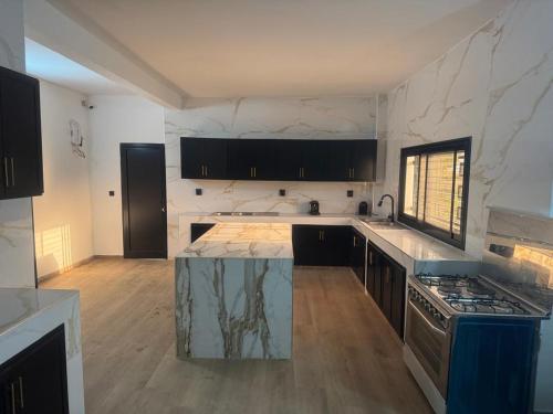 eine Küche mit einer Marmorarbeitsplatte und einem Herd in der Unterkunft Appartement 2 chambres- salon- Cuisine Résidence Aramys Ngaparou in Ngaparou