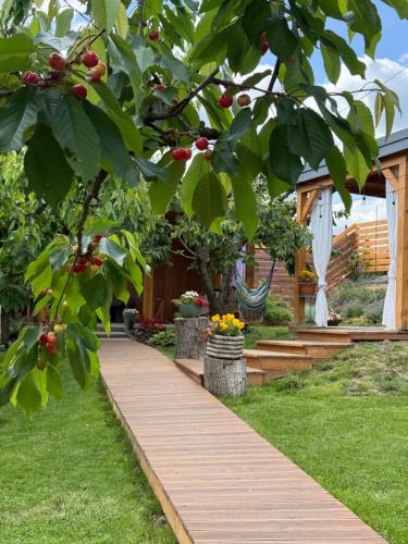 a wooden walkway in a garden with fruit trees at Czereśniowe Wzgórze Sandomierz jakuzzi in Sandomierz