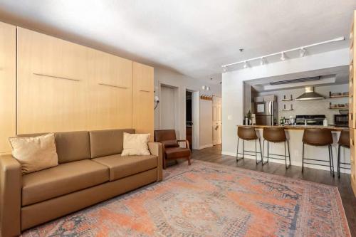Una sala de estar con un sofá y una cocina. en Super-Efficient Studio with Full Kitchen Balcony & Smart Sleeping Options, en Kirkwood