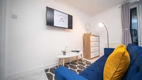 a living room with a blue couch and a table at Pleasant Studio in St Albans in Saint Albans