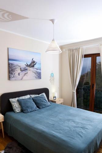 a bedroom with a blue bed and a window at Adria Mare one bedroom apartment in Tušupi