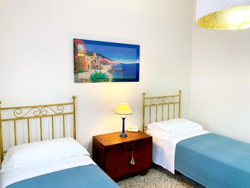 ein Schlafzimmer mit zwei Betten und einem Tisch mit Lampe in der Unterkunft Appartamenti Tina Paolini 2 con terrazzo in Castiglione della Pescaia