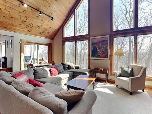 a living room with a couch and chairs and windows at One Ski Hill in McHenry