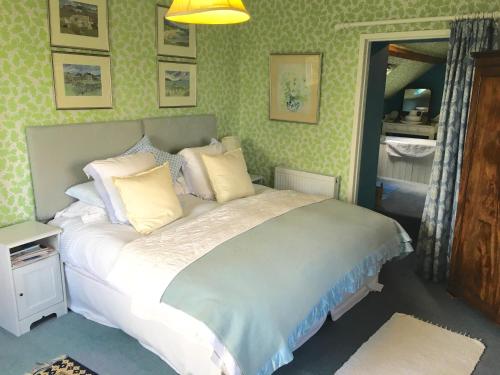 a bedroom with a bed with white sheets and pillows at Cotswolds Mine Hill House in Lower Brailes