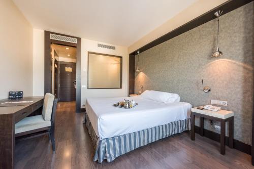 una habitación de hotel con una cama y un escritorio en Hotel Mercader, en Madrid