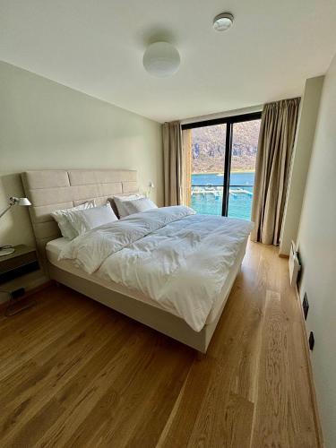 a bedroom with a large bed and a large window at New sea house in Steigen in Steigen