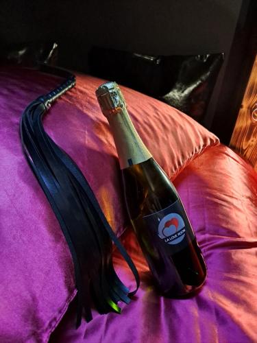 - une bouteille de vin assise au-dessus du lit dans l'établissement La Love room, à Arbois