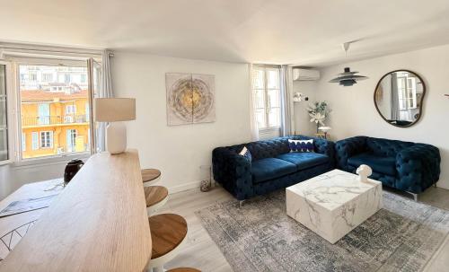 un salon avec un canapé bleu et une table dans l'établissement La vie est belle T2 coeur nice, à Nice