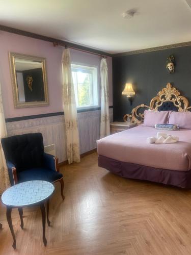 una camera da letto con un letto, una sedia e un tavolo di Auberge Restaurant du Monde a Nominingue