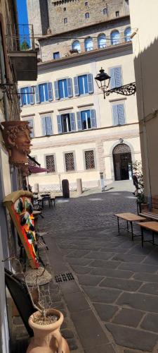 a building with a courtyard with benches in front of it at Casa San Rocco in Bolsena